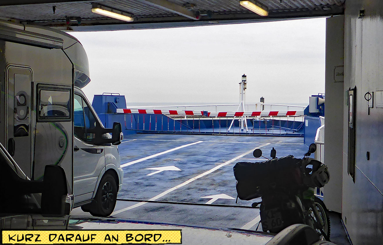 Motorrad und Wohnmobil stehen unter Deck auf einem Fährschiff