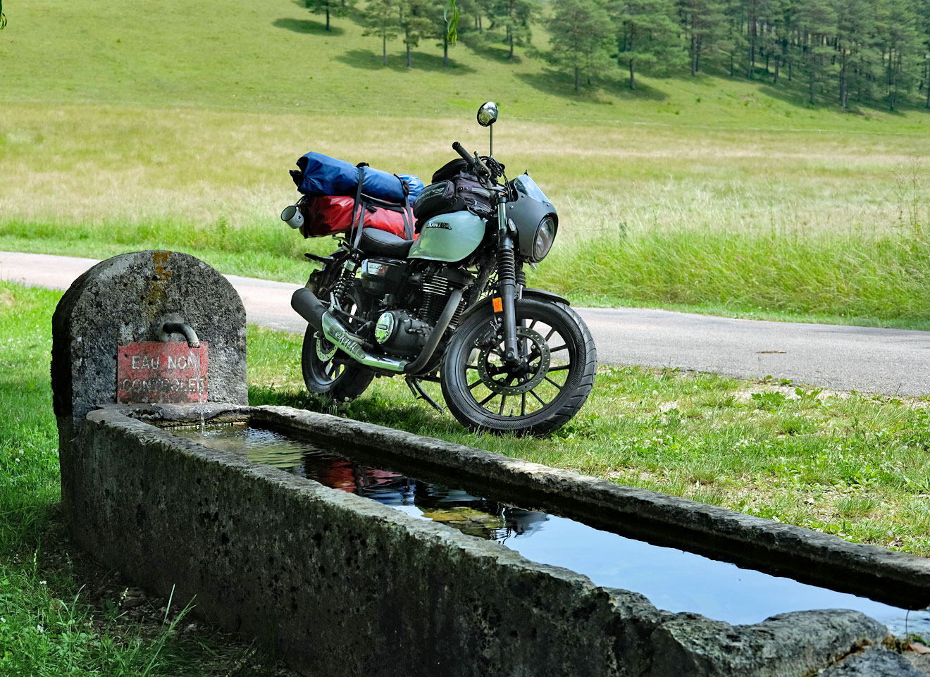 Ein Motorrad steht vor einem Brunnen