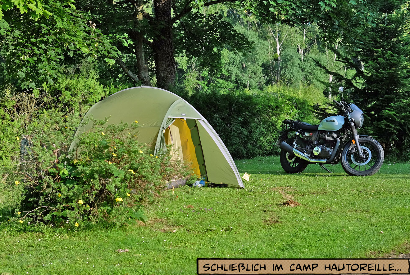 Zelt und Motorrad stehen nebeneinander auf einer Wiese