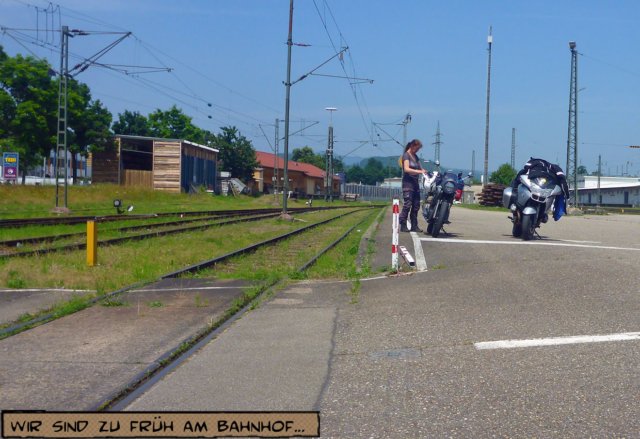 Svenja steht neben ihrem Motorrad am Bahnhof